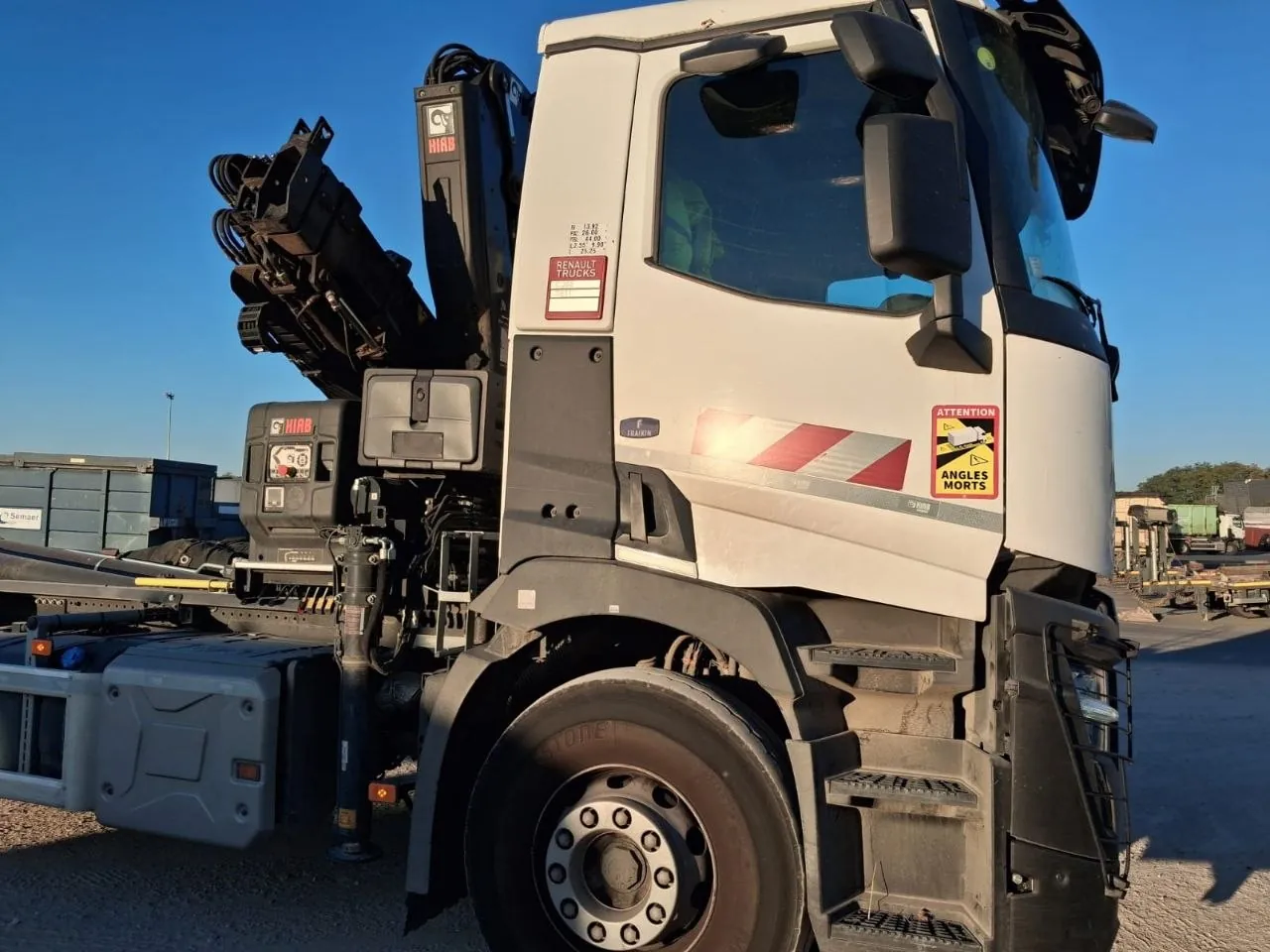 Camion T-K TRANSPORTS à l'arrêt, bras de grue replié, ciel bleu
